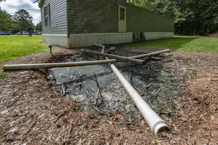 pipes laying in puddle in front of trailer